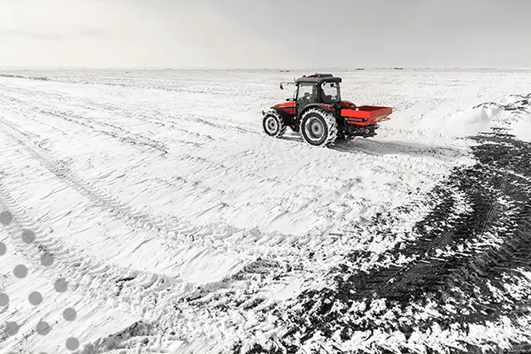 Red tractor working in the snow